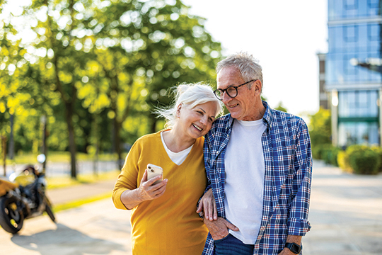IMAGE: Older couple smiling and walking outside