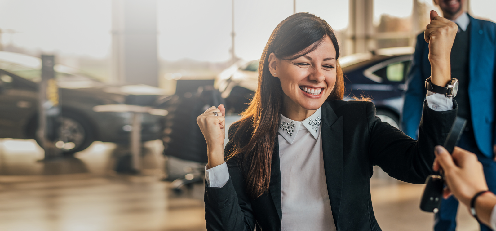 IMAGE: Woman in dealership celebrating new car