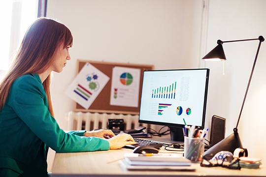 IMAGE: Woman working on computer at a desk