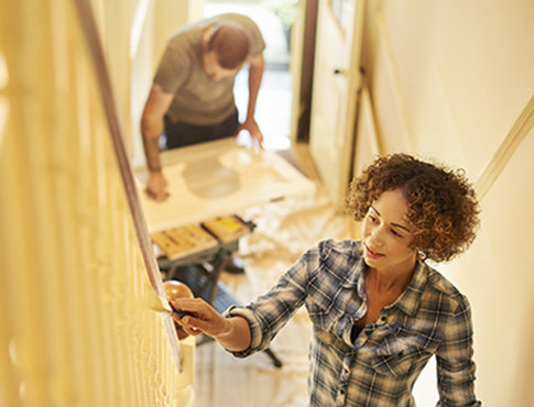 IMAGE: Couple painting stairway and making home improvements.