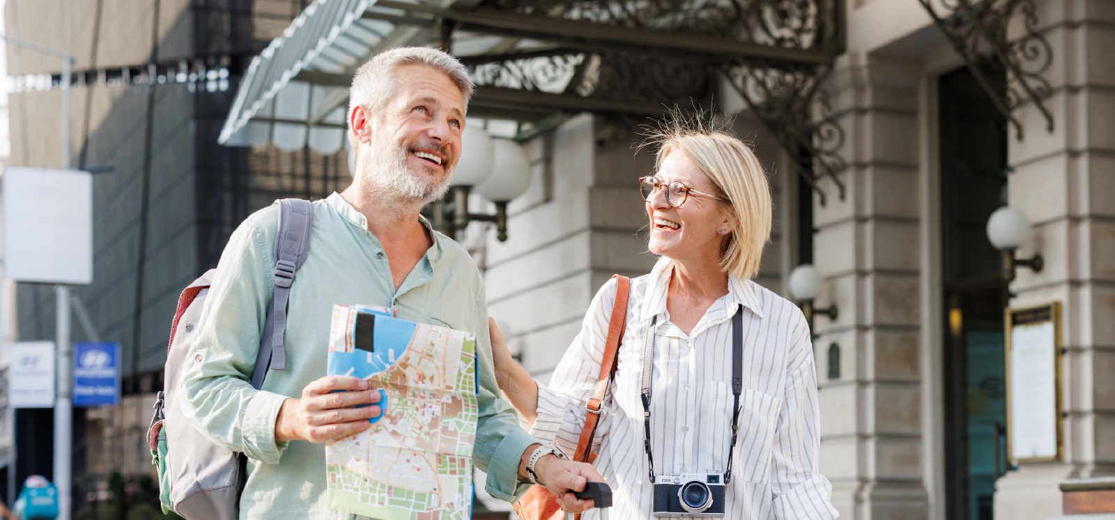 IMAGE: Couple traveling together holding a map and camera