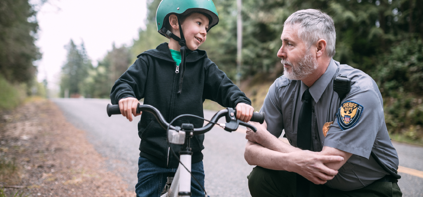 IMAGE: Kid on bike talking to officer from the sheriff's office