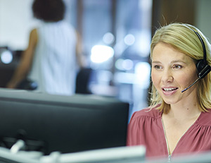 IMAGE: Woman talking with headset in an office