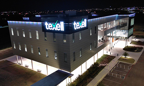 IMAGE: Texell headquarters at night with green and white lights along the roof line