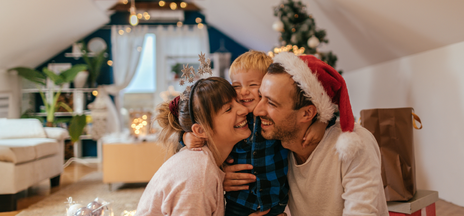 IMAGE: Family hugging in living room decorated for the holidays