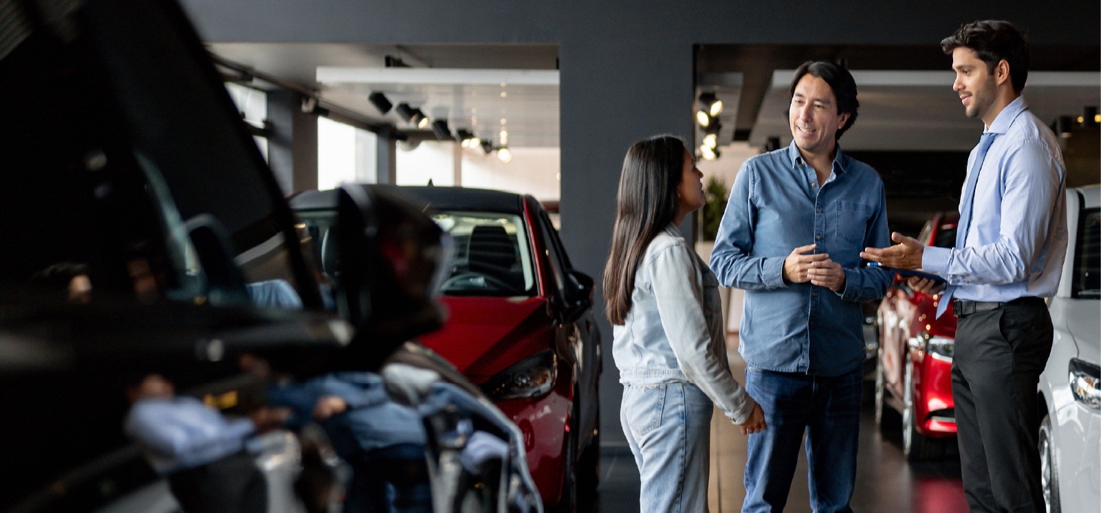 Image: Couple at dealership shopping for a used car.