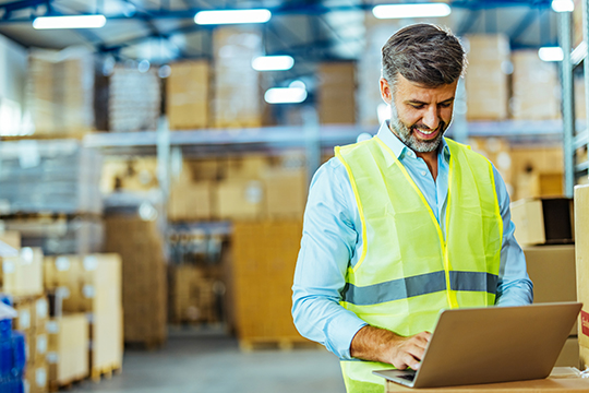IMAGE: Man working on laptop in a warehouse