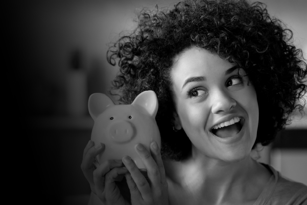 IMAGE: Woman smiling while holding a piggy bank