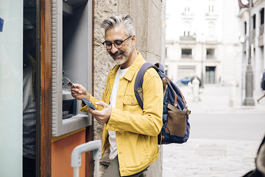IMAGE: Man using outdoor ATM in a city outside the United States