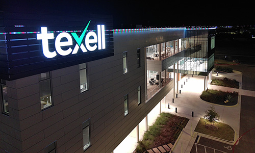 IMAGE: Texell headquarters at night with red white and green lights along the roof line