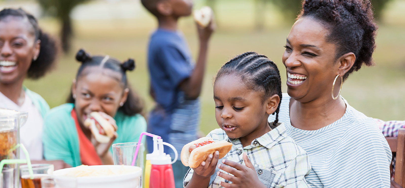 IMAGE: Family eating hot dogs at a backyard BBQ