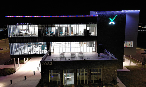 IMAGE: Texell headquarters at night with red, white, and blue lights along the roof line
