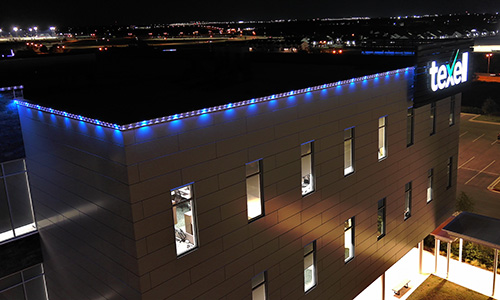 IMAGE: Texell headquarters at night with blue running lights along the roof line